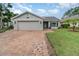 Charming home featuring a brick driveway, attached garage, and well-manicured lawn and front garden at 1096 Dees Dr, Oviedo, FL 32765