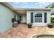 Inviting front porch with brick pavers, potted plants, and a cozy seating area at 1096 Dees Dr, Oviedo, FL 32765