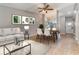 A bright living room featuring a modern sofa, dining table, and ceiling fan at 1096 Dees Dr, Oviedo, FL 32765