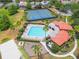 Overhead view of community amenities including a pool, playground, and tennis courts surrounded by greenery at 11878 Via Lucerna Cir, Windermere, FL 34786