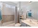Cozy bathroom with a tub-shower combo, blue vanity, decorative shelves and a white-tile accent wall at 11878 Via Lucerna Cir, Windermere, FL 34786