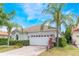 Single-story home showcasing a two-car garage, tiled roof, and a well-manicured front yard at 11878 Via Lucerna Cir, Windermere, FL 34786