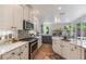 Bright kitchen with white cabinets, stainless steel appliances, and an open view to the living room at 11878 Via Lucerna Cir, Windermere, FL 34786