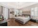 Spacious main bedroom with hardwood floors, tray ceiling, and natural light from shuttered windows at 11878 Via Lucerna Cir, Windermere, FL 34786
