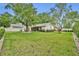 Expansive backyard features lush green grass, mature trees, and a patio, ideal for outdoor living at 1218 Fairway Dr, Winter Park, FL 32792