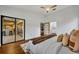 Bright bedroom featuring a sleek ceiling fan, hardwood floors and an open doorway to the kitchen bar at 1218 Fairway Dr, Winter Park, FL 32792