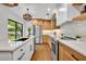 Bright kitchen with stainless steel appliances, quartz countertops, and a view to the backyard at 1218 Fairway Dr, Winter Park, FL 32792