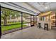 Relaxing screened-in patio with tiki bar, tiled flooring, and backyard views offers indoor-outdoor living at 1218 Fairway Dr, Winter Park, FL 32792