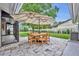 Outdoor stone patio features a wood table and chairs under a patio umbrella with screened-in room access at 1218 Fairway Dr, Winter Park, FL 32792