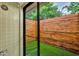 Outdoor shower with a clear glass enclosure and a decorative wood privacy fence and artificial turf at 1218 Fairway Dr, Winter Park, FL 32792