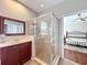 Bathroom showcasing a walk-in shower with glass enclosure and double vanity with framed mirror at 12724 Bideford Ave, Windermere, FL 34786