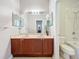 Bathroom featuring dual sinks, wood cabinets, and a tiled shower/tub combination at 12724 Bideford Ave, Windermere, FL 34786