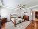 Airy bedroom with hardwood floors, ceiling fan, tray ceiling, and three windows letting in plenty of natural light at 12724 Bideford Ave, Windermere, FL 34786