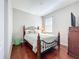 Cozy bedroom featuring hardwood floors, an ornate metal bed frame, and a large window for natural light at 12724 Bideford Ave, Windermere, FL 34786
