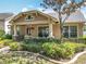 Inviting single-Gathering home boasts a lush front yard, spacious porch with decorative hanging baskets, and large windows at 12724 Bideford Ave, Windermere, FL 34786