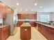 Open kitchen featuring stainless steel appliances, tile floors, wood cabinets, and granite countertops at 12724 Bideford Ave, Windermere, FL 34786