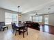 Open concept dining and living room with hardwood floors, large windows, modern lighting and a large leather couch at 12724 Bideford Ave, Windermere, FL 34786