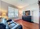 Cozy living room featuring hardwood flooring, a large window with blinds and a leather couch at 12724 Bideford Ave, Windermere, FL 34786