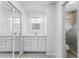 Bright bathroom featuring a single sink vanity with mirrored closet, and a walk-in shower at 135 Heron Bay Cir, Lake Mary, FL 32746