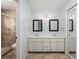 A spacious bathroom featuring a double sink vanity, framed mirrors, and a walk-in shower at 135 Heron Bay Cir, Lake Mary, FL 32746