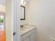Neat half bath with a marble countertop, decorative mirror, and neutral wall paint at 135 Heron Bay Cir, Lake Mary, FL 32746
