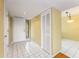 A brightly lit hallway with white tile flooring and two doors, including one louvered door at 135 Heron Bay Cir, Lake Mary, FL 32746