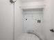 Functional laundry room with white tile floors, wire shelving and utility connections at 135 Heron Bay Cir, Lake Mary, FL 32746