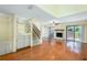 Open-concept living room with hardwood floors, fireplace, bar, and staircase access at 135 Heron Bay Cir, Lake Mary, FL 32746