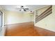 Open living area with hardwood floors, ceiling fan, and stairway access to upper level at 135 Heron Bay Cir, Lake Mary, FL 32746