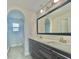 Bathroom with double sinks, modern lighting, vanity with dark wood grain cabinets and shower at 144 Angelas Ave, Haines City, FL 33844