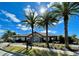 The community clubhouse is framed by swaying palm trees, offering residents a place to relax, socialize, and enjoy amenities at 144 Angelas Ave, Haines City, FL 33844