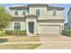 Two-story home featuring neutral paint, attached two-car garage, well-maintained landscaping and a brick driveway at 144 Angelas Ave, Haines City, FL 33844