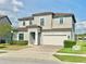 Two-story home featuring neutral paint, attached two-car garage, well-maintained landscaping and a brick driveway at 144 Angelas Ave, Haines City, FL 33844