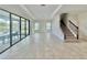 Bright, spacious living room with tile floors, sliding glass doors, and a staircase to the second floor at 144 Angelas Ave, Haines City, FL 33844