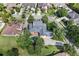Overhead view of landscaped yellow two-story home with pool, patio, three car garage and mature trees at 1448 Conway Isle Cir, Belle Isle, FL 32809