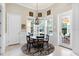 Bright dining area with a round table set, chandelier, and large bay windows offering natural light and backyard views at 1448 Conway Isle Cir, Belle Isle, FL 32809