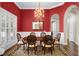 Formal dining room features red walls, chandelier, hardwood floors, and an arched doorway at 1448 Conway Isle Cir, Belle Isle, FL 32809