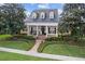 Inviting yellow home showcasing a manicured lawn, brick path and white pillared porch beneath a dark roof at 1448 Conway Isle Cir, Belle Isle, FL 32809