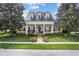 Charming yellow home showcasing a manicured lawn and white pillared porch beneath a dark roof at 1448 Conway Isle Cir, Belle Isle, FL 32809