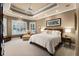 Serene main bedroom with tray ceiling, plantation shutters, and cozy seating area, creating a relaxing retreat at 1448 Conway Isle Cir, Belle Isle, FL 32809
