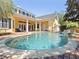 Beautiful backyard pool with brick paver deck, water feature and covered lanai on yellow two-story home at 1448 Conway Isle Cir, Belle Isle, FL 32809