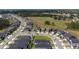 An aerial view of a residential area with homes, green spaces, and a pond at 16301 Sanctuary Reserve Loop, Clermont, FL 34714