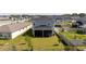 An aerial view of the home's backyard with a screened-in patio, fencing, and mature trees at 16301 Sanctuary Reserve Loop, Clermont, FL 34714
