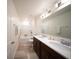 Bathroom with dual vanities, a large mirror, a shower/tub, and modern fixtures at 16301 Sanctuary Reserve Loop, Clermont, FL 34714