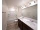 Modern bathroom with dual sinks, large mirror, and a shower-tub combination at 16301 Sanctuary Reserve Loop, Clermont, FL 34714