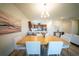Dining room with chandelier and art, flowing into a modern kitchen and living area at 16301 Sanctuary Reserve Loop, Clermont, FL 34714