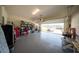 Spacious garage with overhead door open to the driveway and organized storage on shelving units at 16301 Sanctuary Reserve Loop, Clermont, FL 34714