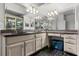 Bathroom featuring black countertops, black and white tile floors, and a large mirror with unique lighting at 16500 Quarter Horse Ct, Montverde, FL 34756