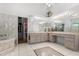 Bright bathroom featuring tile floors, dual vanity, walk-in shower and separate soaking tub at 16500 Quarter Horse Ct, Montverde, FL 34756