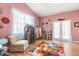 Pink bedroom featuring colorful decor, a flower rug, and access to double doors at 16500 Quarter Horse Ct, Montverde, FL 34756